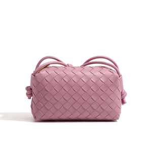 Pink woven handbag on a white background