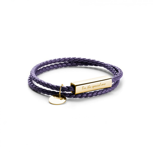 A purple braided cord bracelet with a gold-plated rectangular nameplate engraved with 'For the special one' and a small round gold tag, shown on a plain white background.