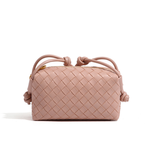 Blush pink woven handbag with drawstring on a white background
