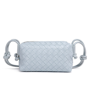 Light blue woven handbag with handle on a white background