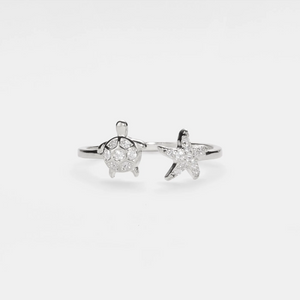 Stapelring mit Meeresschildkröte und Seestern am Strand