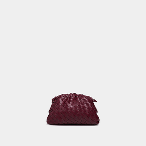 Maroon woven handbag on a light gray background