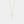 Gold cross necklace on a light gray background