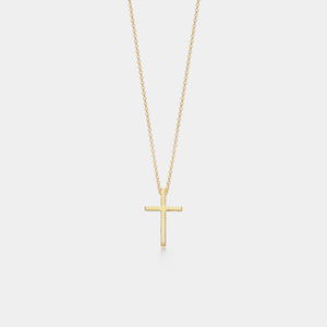 Gold cross necklace on a light gray background