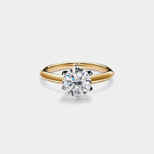 Gold ring with a diamond on a light gray background