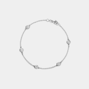 Silver bracelet with small round moissanite on a white background