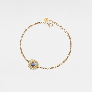 Gold bracelet with a sunflower-shaped charm and projection gemstone on a light gray background