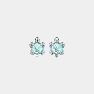 Pair of sea turtle-shaped earrings with blue gemstones on a light gray background