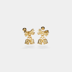 Gold bow-shaped earrings with bell charms on a light gray background