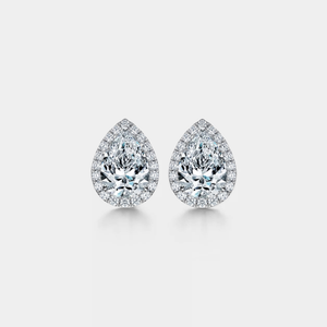 Pair of pear-shaped moissanite earrings on a light gray background