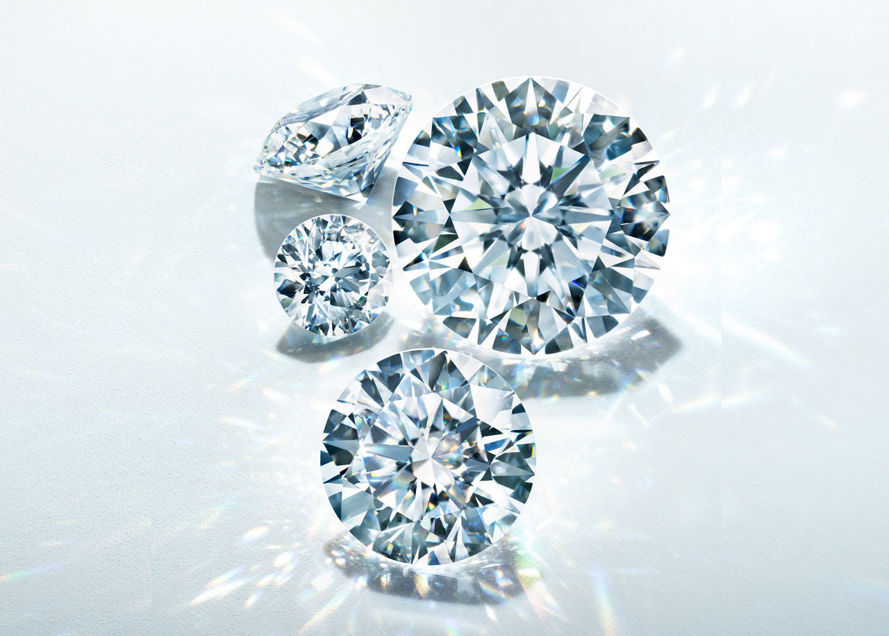 Three diamonds of different shapes and sizes on a light gray background