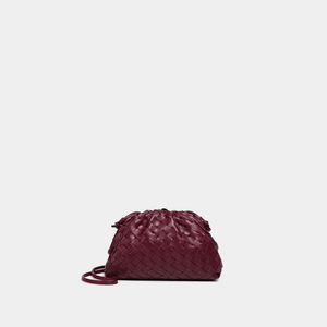 Maroon woven handbag on a light gray background