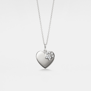 Heart-shaped locket pendant with paw print design on a chain against a light gray background