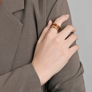 Model wearing interlocking triple band gold ring with red crystal, elegant stackable statement ring