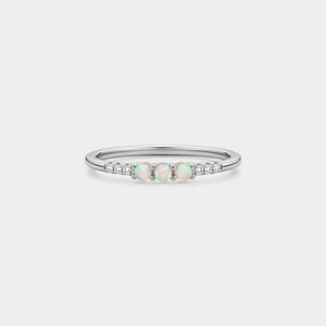 Silver ring with opal stones and diamonds on a light gray background