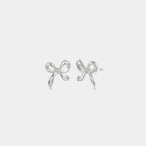 Silver bow-shaped earrings on a light gray background