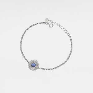 Silver bracelet with a sunflower-shaped charm and projection gemstone on a light gray background