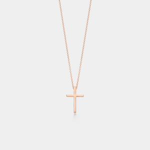 Rose gold cross necklace on a light gray background