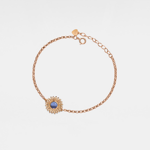 Rose gold bracelet with a sunflower-shaped charm and projection gemstone on a light gray background