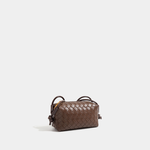 Brown woven handbag on a light gray background