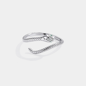 Silver snake-shaped ring with green gemstones on a light gray background