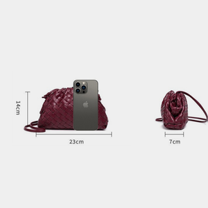 Maroon handbag with dimensions and an iPhone for scale on a white background