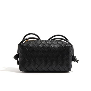 Black woven handbag on a white background