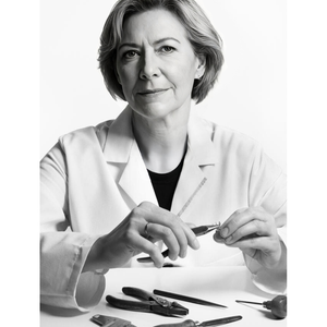Person holding a tool with various tools on a table in a black and white photo