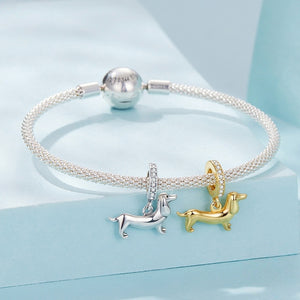 A bracelet with two dachshund charms on a blue background