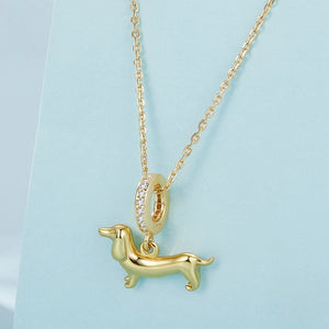 Gold necklace with a dachshund charm on a blue background