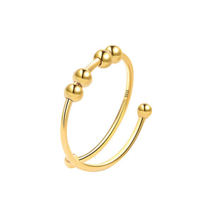 Gold ring with spherical beads on a white background