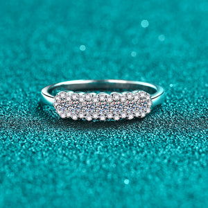 Silver ring with embedded moissanite on a teal glittery background