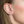 Woman wearing earrings designed to resemble a snake, with a gold plating on sterling silver