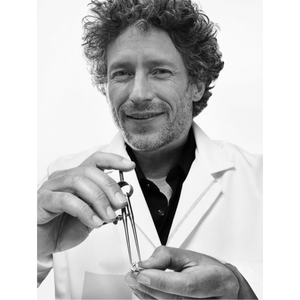 Black and white photo of a person holding an engagement ring, wearing a lab coat.