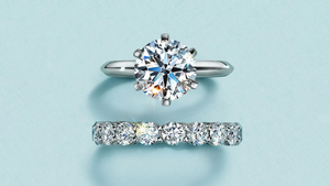 Diamond ring and bar necklace on a light blue background