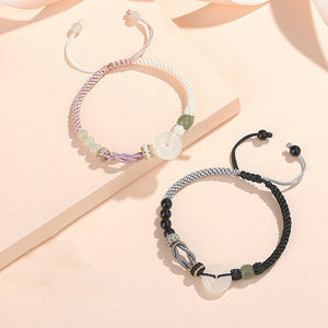 Two bracelets with beaded designs on a light pink background