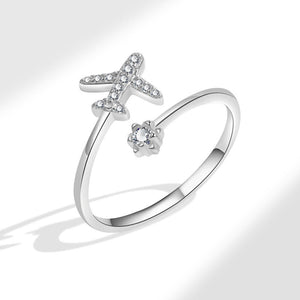 Silver ring featuring a star and airplane design with cubic zirconia embellishments.