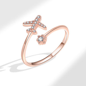 Rose gold ring featuring a star and airplane design with cubic zirconia embellishments.
