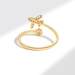 Gold ring featuring a star and airplane design with cubic zirconia embellishments.
