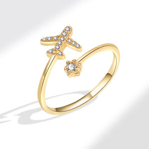 Gold ring featuring a star and airplane design with cubic zirconia embellishments.