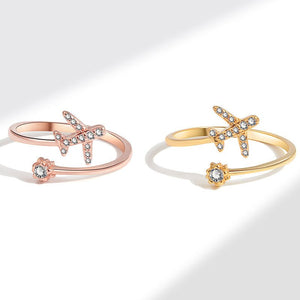 Two bypass rings, one with a rose gold finish and the other with a gold finish, each featuring a star-shaped airplane design with cubic zirconia embellishments.
