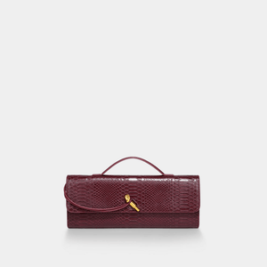 Burgundy handbag with a gold clasp on a white background