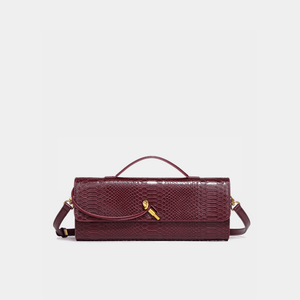 Maroon handbag with gold clasp on a light gray background