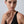 Woman wearing a gold ring on a plain background
