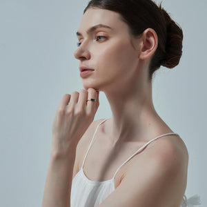 Woman wearing a white tank top against a plain background
