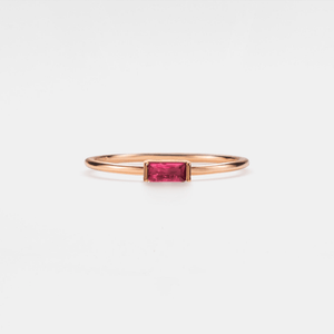 A gold-plated sterling silver band ring with a central baguette-cut birthstone surrounded by smaller baguette-cut stones.