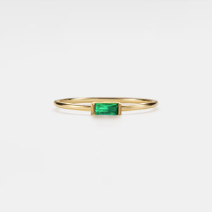 A gold-plated sterling silver band ring with a central baguette-cut birthstone surrounded by smaller baguette-cut stones.