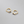 Gold hoop earrings with purple gemstones on a gray background