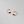 Gold hoop earrings with red gemstones on a gray background