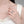 Close-up of a hand wearing a silver ring on a neutral background
